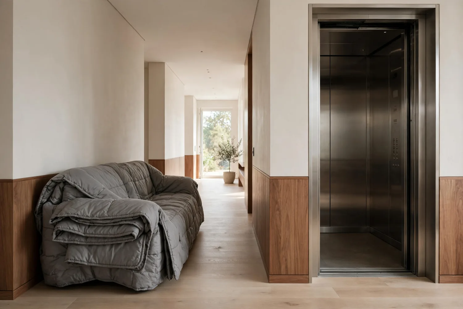 A wrapped sofa beside an elevator
